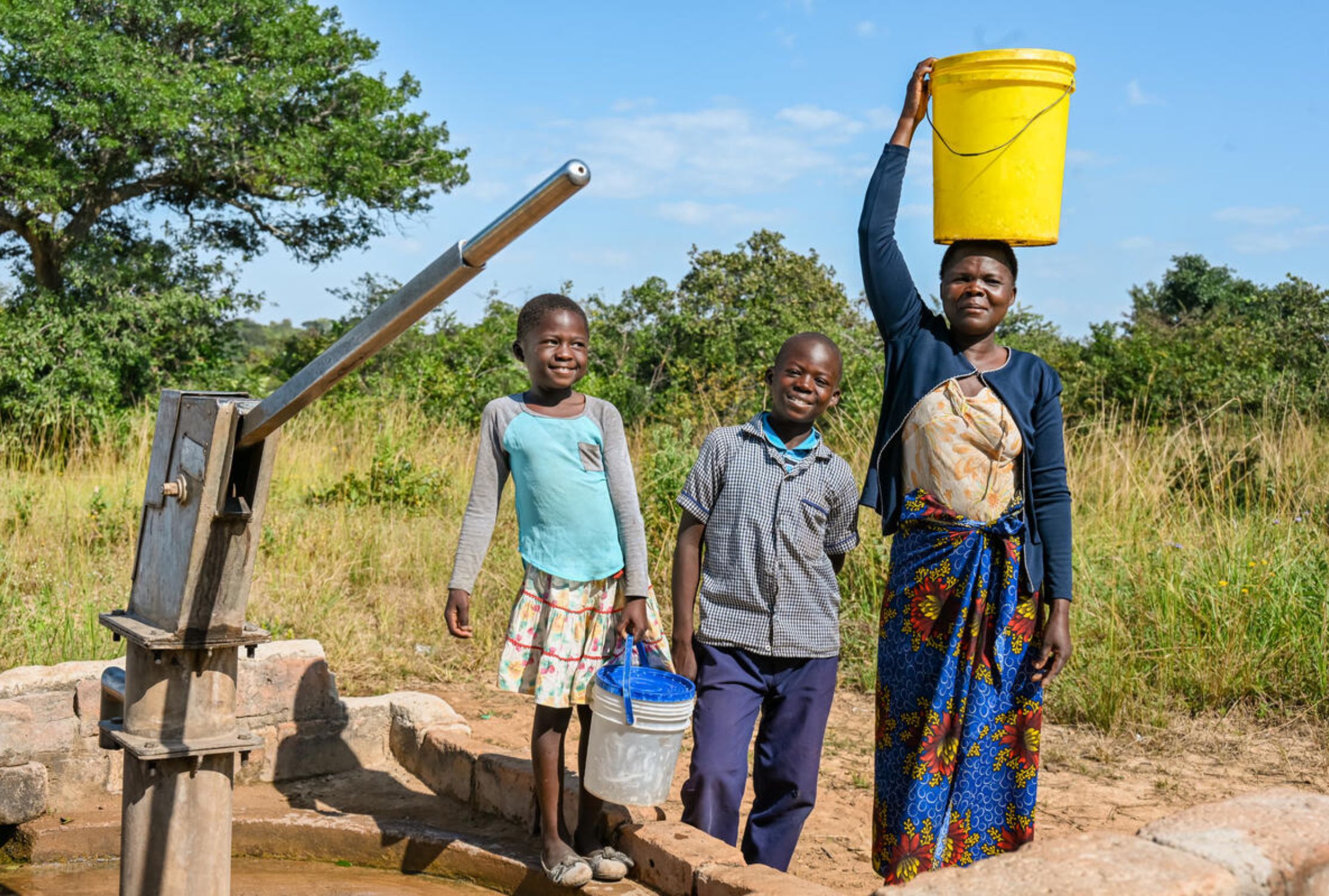 Zambian family collecting water from a hand pump