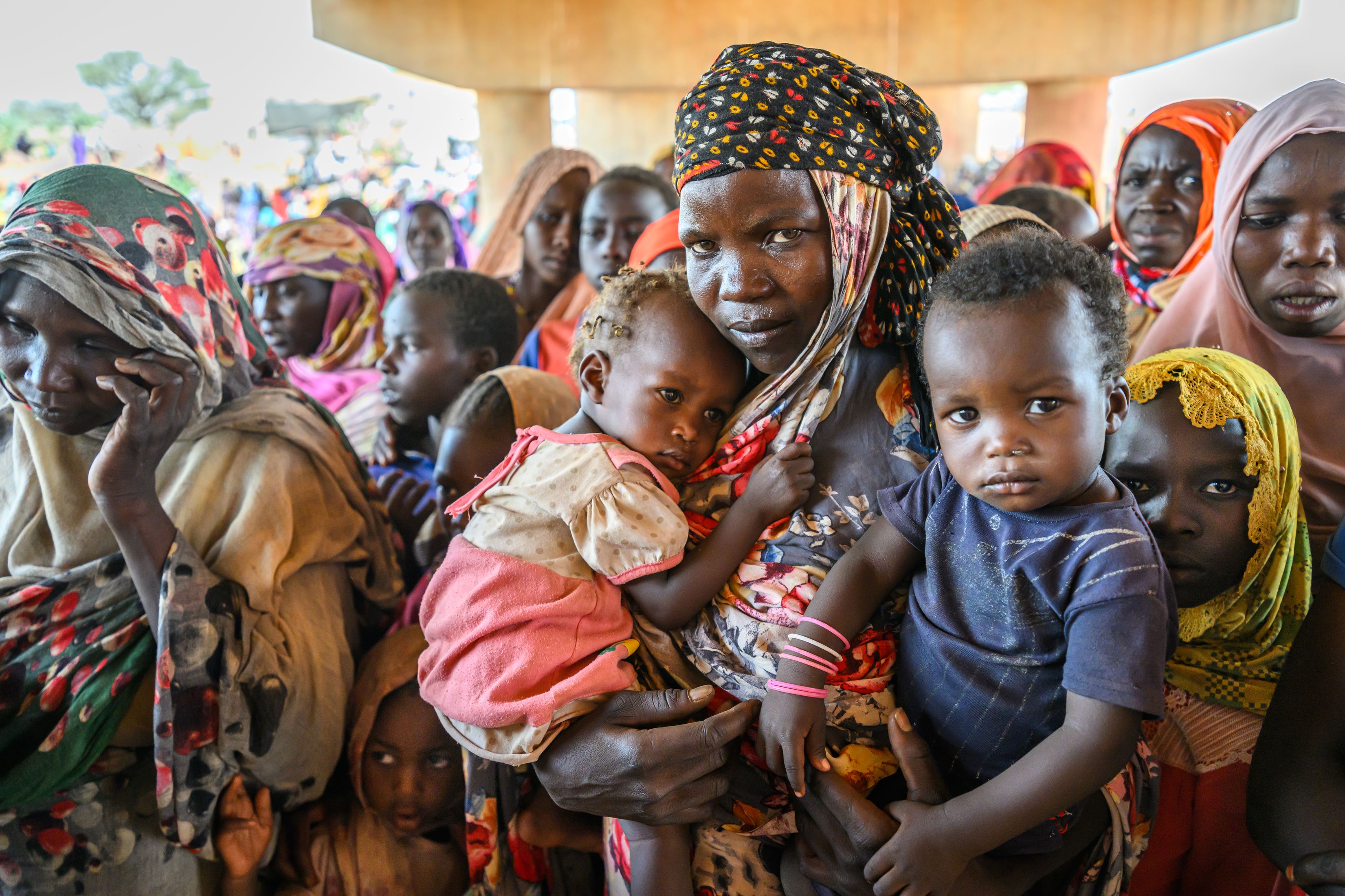 A mother holding her baby and toddler in Chad