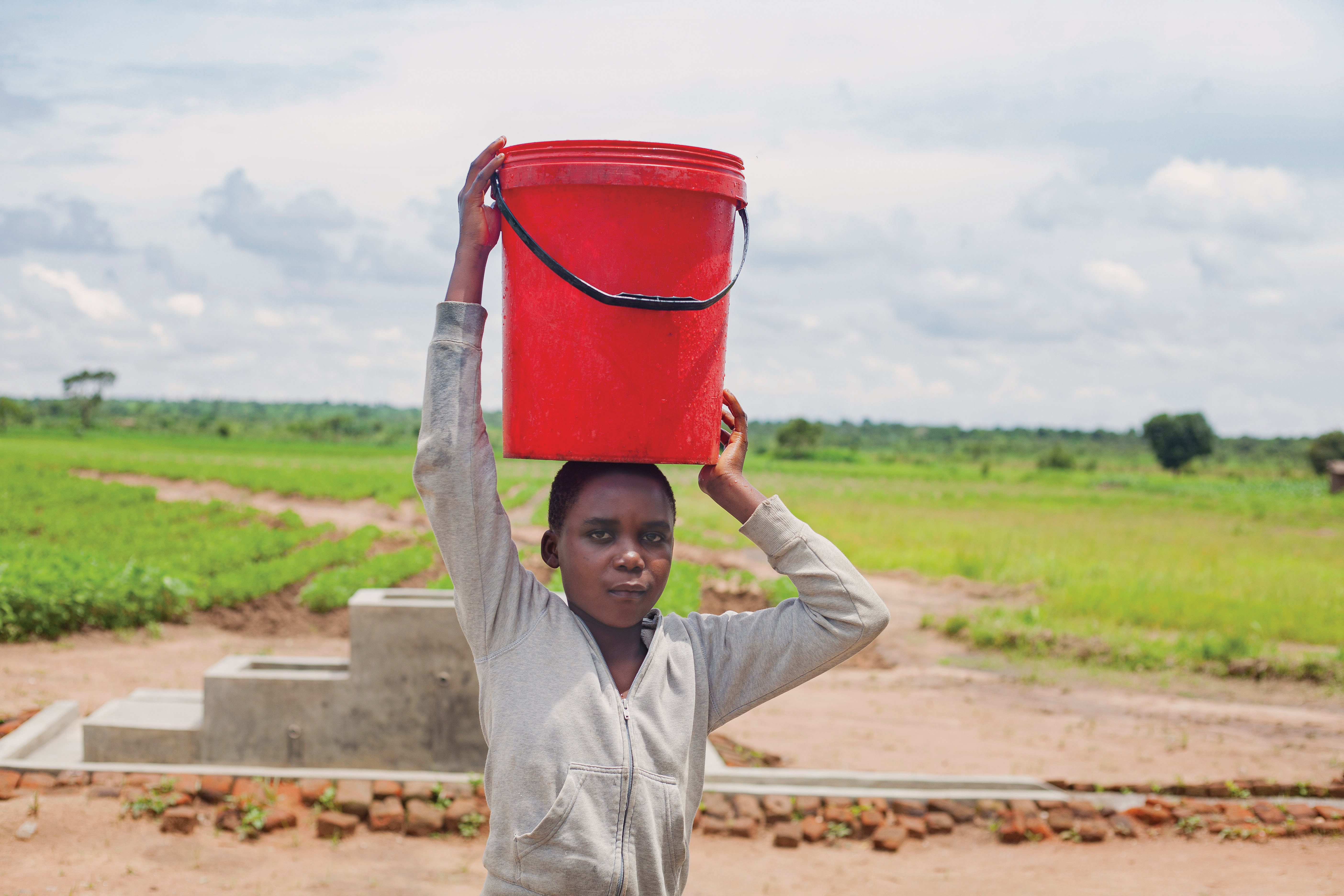 Girl carries bucked of water