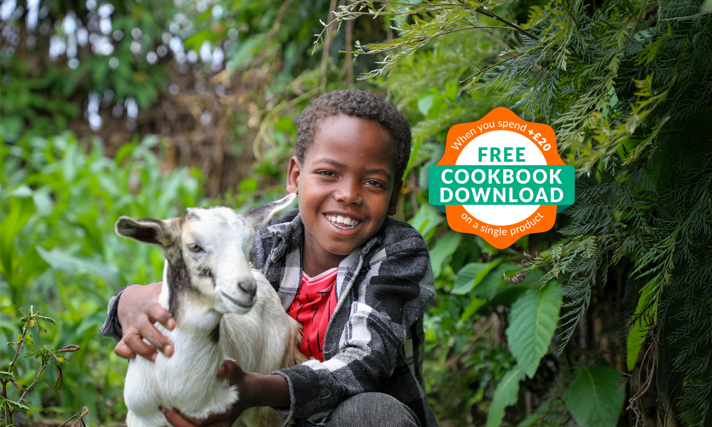 Child from Ethiopia standing outside holding a goat and smiling to the camera