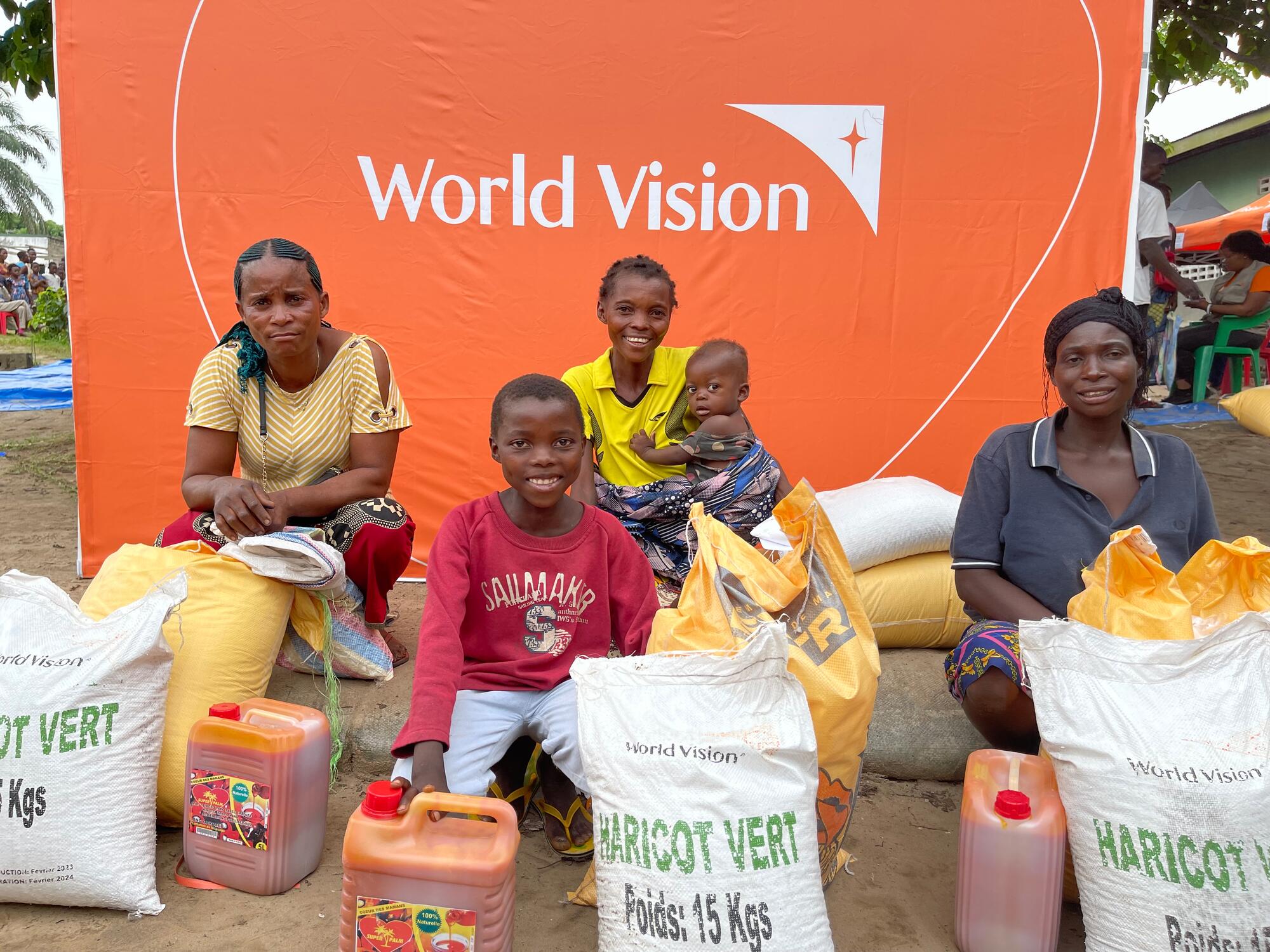  Children in DRC sit with bags of emergency aid provided by World Vision