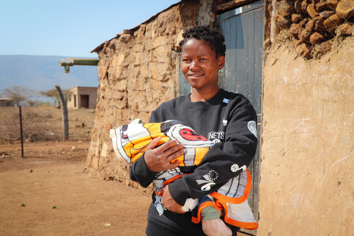 A mother holds her baby wrapped in a warm blanket, Eswantini