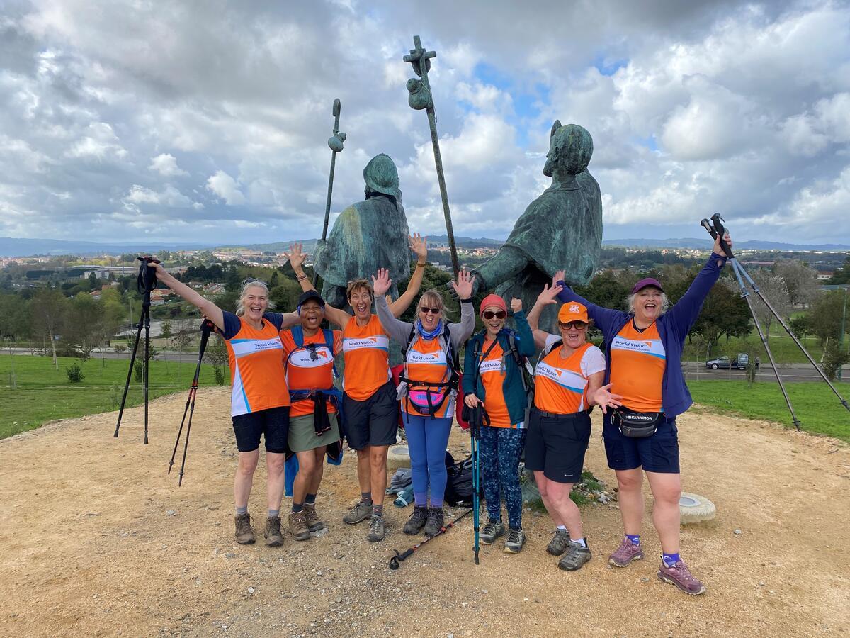 World Vision supporters cheering in front of some statues along the Camino de Santigo