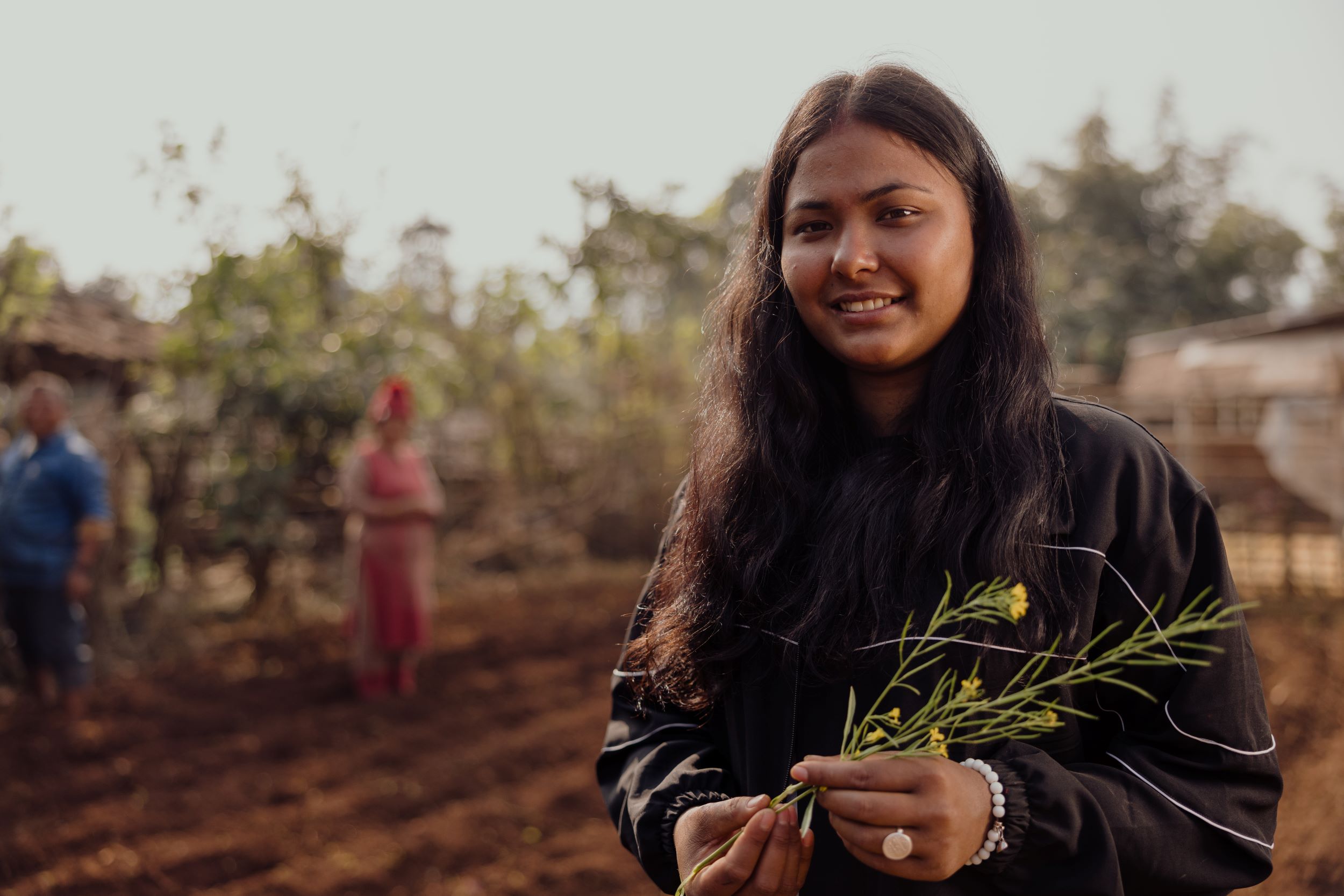 Januka, 18, stands in front of the garden she set up, creating a supply of vegetables to her community