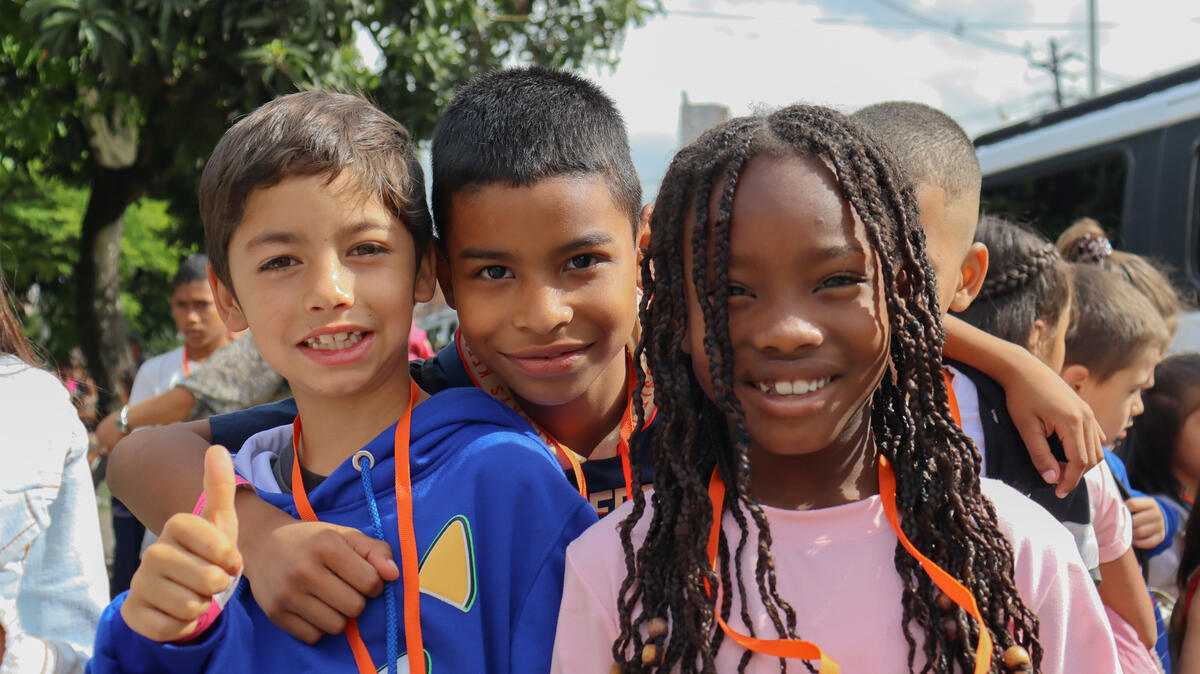 Three sponsored children from Colombia smile to the camera