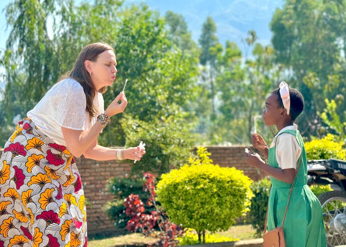 Girl meets her sponsor in Malawi, and they blow bubbles in a garden