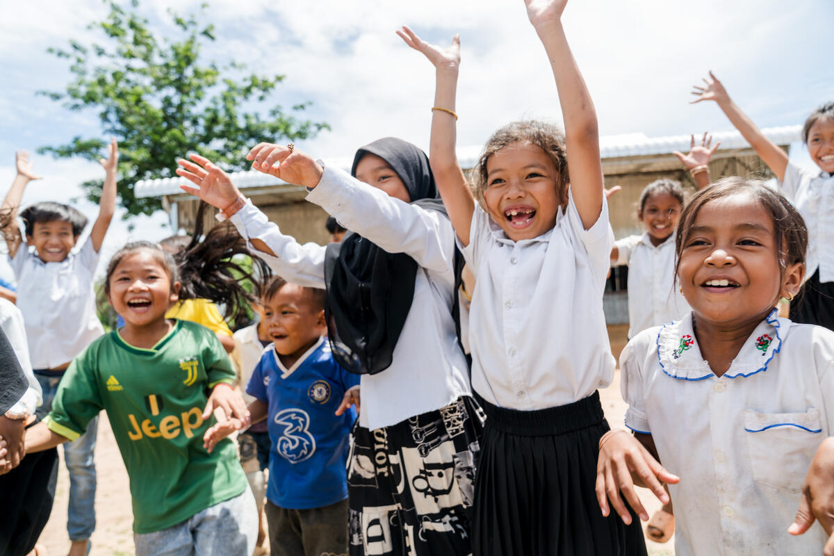 A group of children from Cambodia jumping about energetically and happily