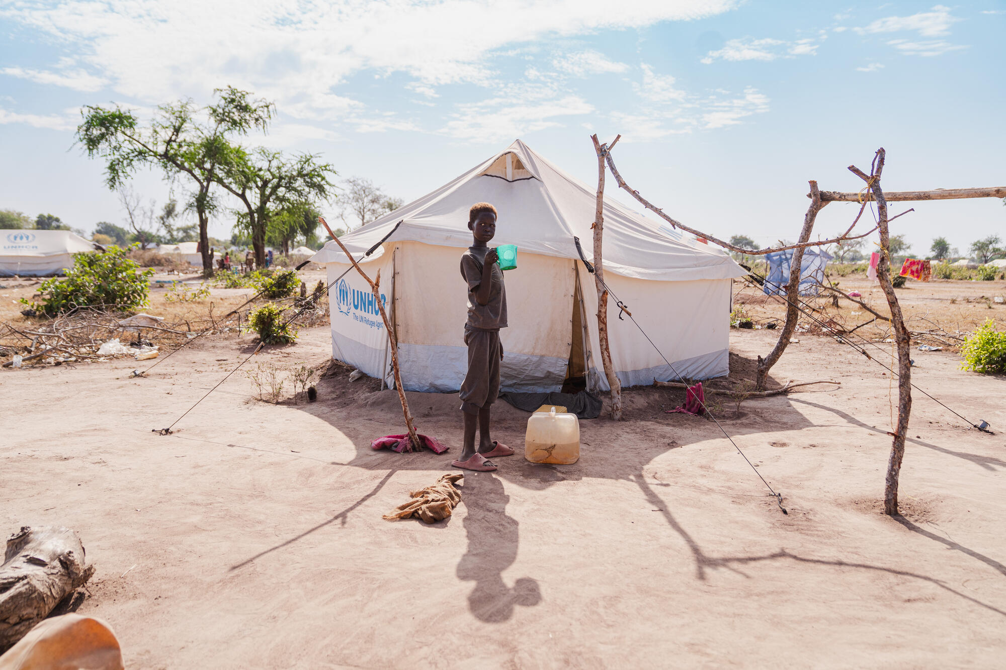 A child stands in front of tent at Wedweill Refugee Settlement in South Sudan